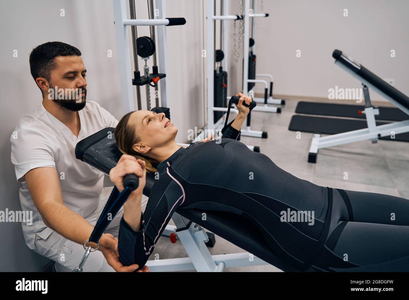 Doctor kinesiologist provides muscle therapy exercises for woman arms