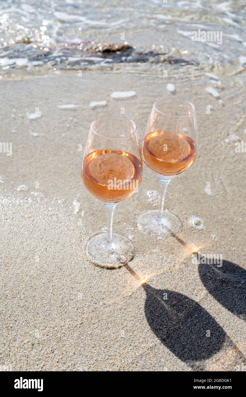 Summer time in Provence, two glasses of cold rose wine on sandy beach near Saint-Tropez in sunny day, Var department, France Stock Photo