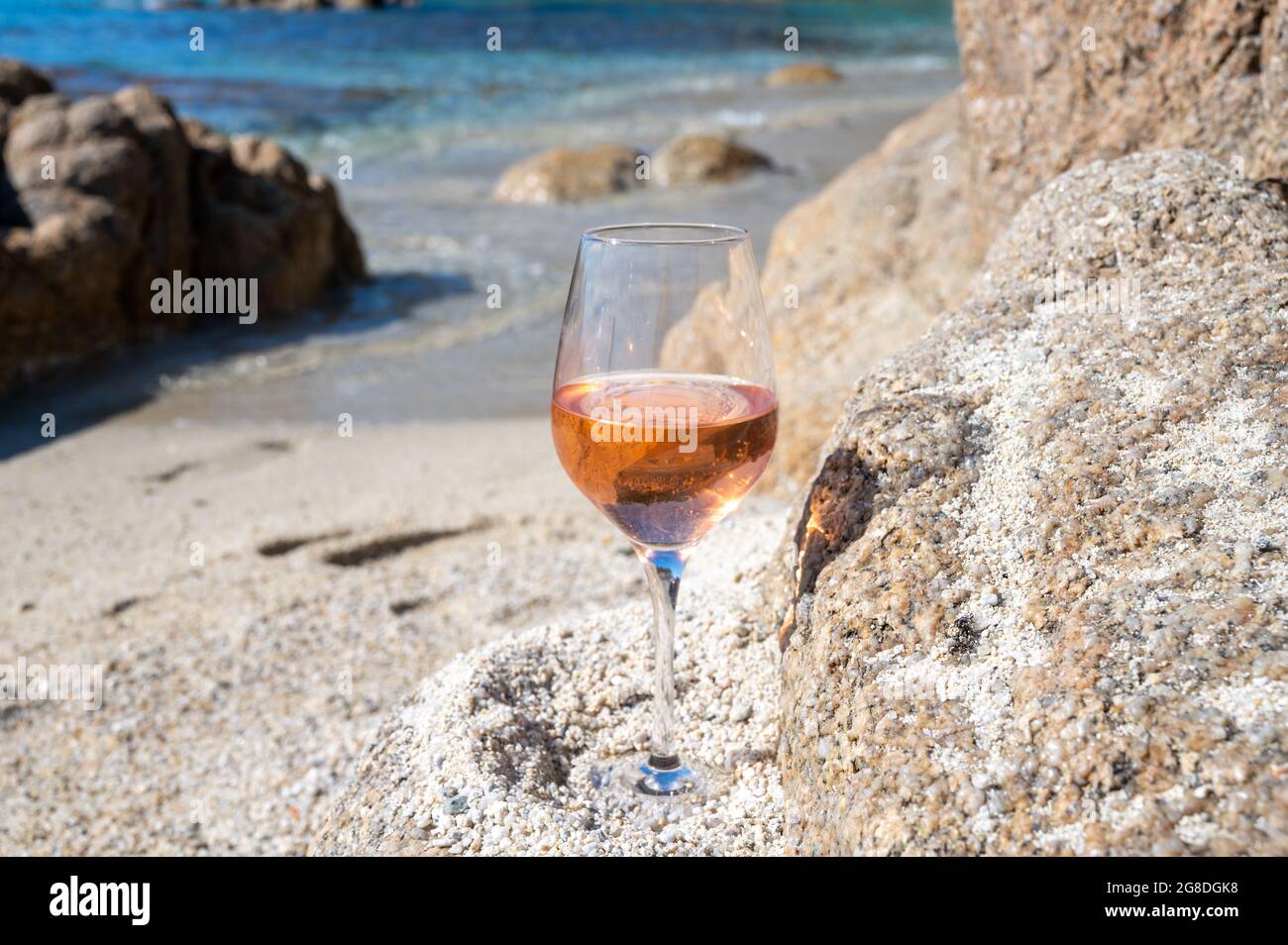 Summer time in Provence, glass of cold rose wine on sandy beach near Saint-Tropez in sunny day, Var department, France Stock Photo