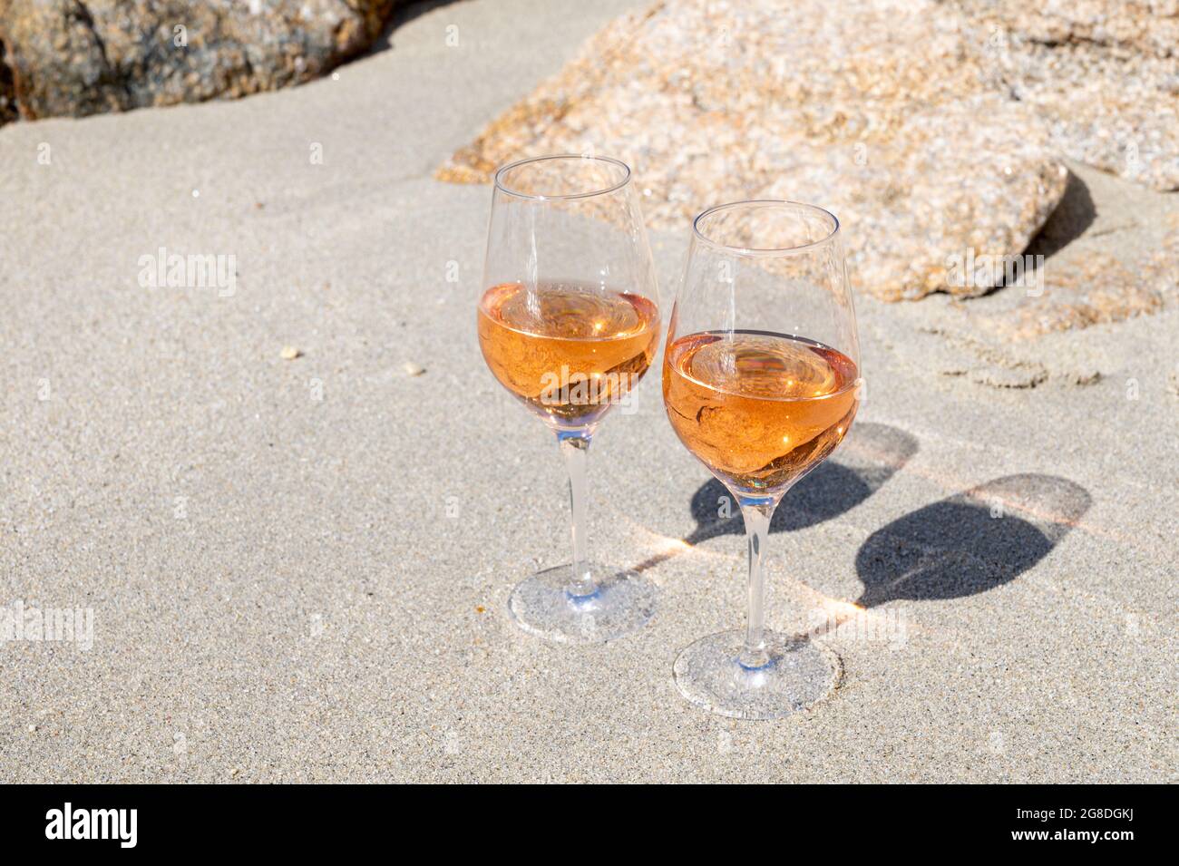 Summer time in Provence, two glasses of cold rose wine on sandy beach near Saint-Tropez in sunny day, Var department, France Stock Photo