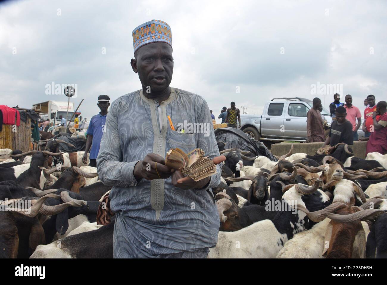 A ram vendor counting money from customers at the Kara Cattle Market