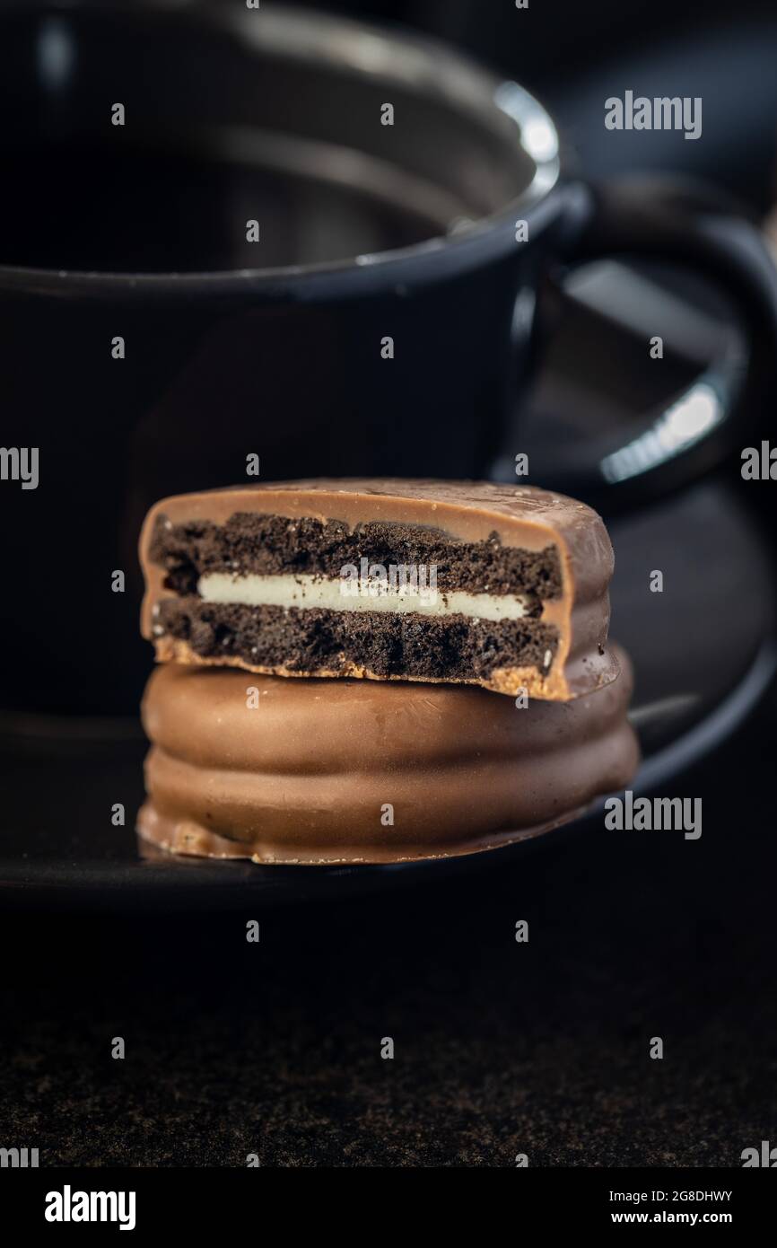 Biscuits with chocolate icing on black table. Stock Photo