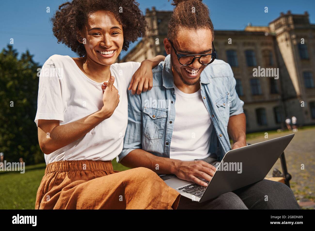 Delighted young couple using modern gadget outdoors Stock Photo
