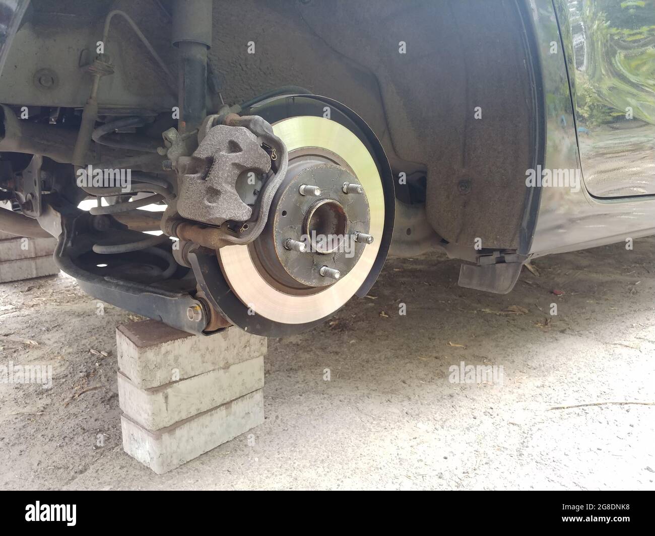 close-up of a stolen car wheel with brake disk and shaft standing on a bricks Stock Photo