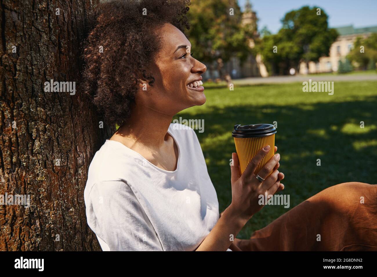Beautiful dark haired woman sitting with coffee in the park Stock Photo ...