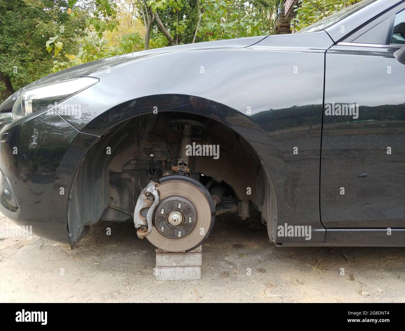 car standing on a bricks with stolen wheel. depict insurance from