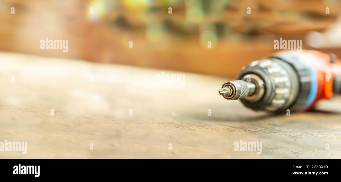 Close-up of a cordless screwdriver on a workbench. Wide screen with text space Stock Photo