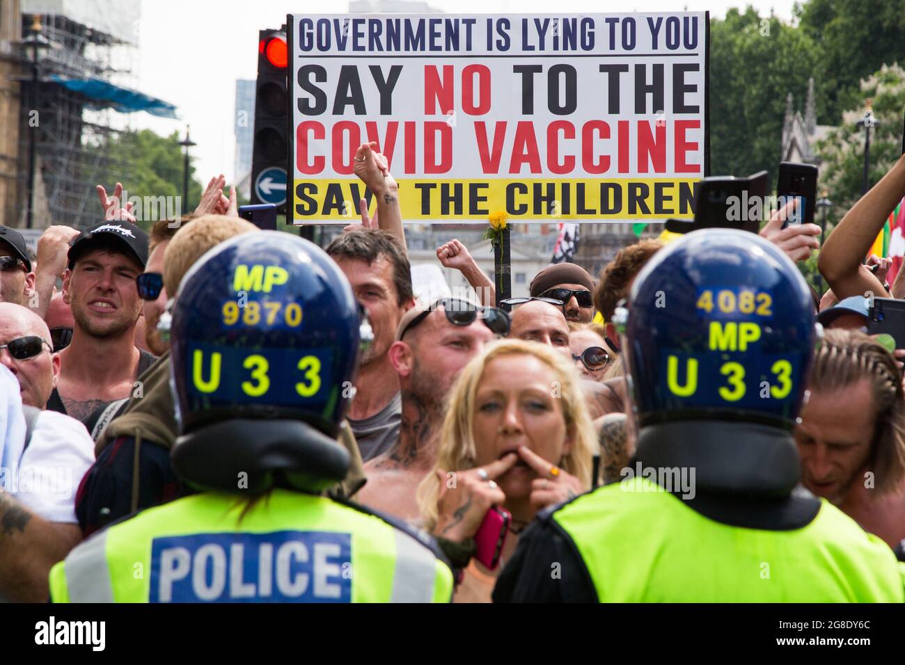 London, UK. 19th July, 2021. Police in riot gear form a cordon in front of protesters during the protest.Anti-vaccination and anti-Covid restrictions demonstrators march to Parliament Square. They say the coronavirus pandemic is a hoax and protest against the idea of vaccine passports. Credit: SOPA Images Limited/Alamy Live News Stock Photo