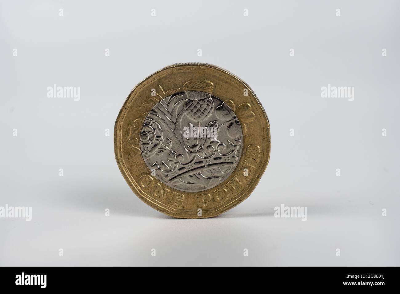 British one pound coin macro photo. Coin withn the signs of circulation, worn state. Isolated on white. Stock Photo
