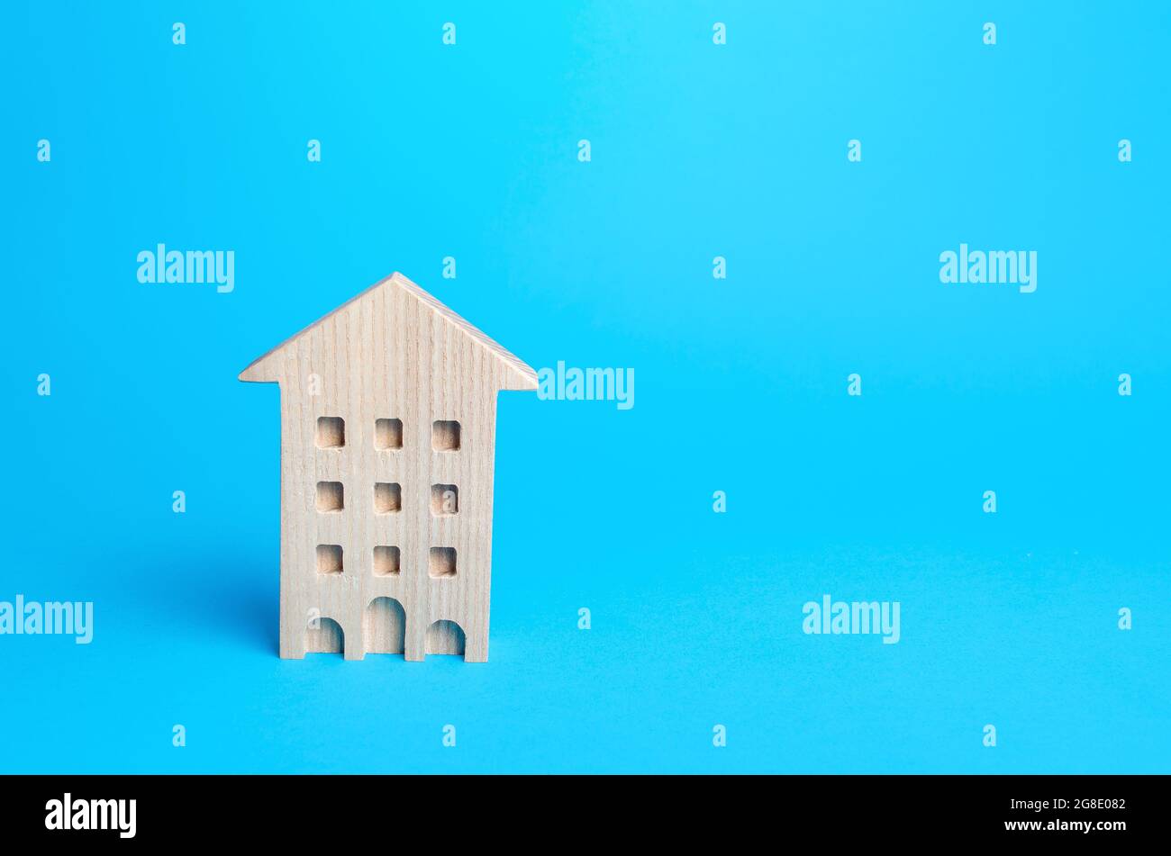 Wooden multi-storey house on a blue background. Buying and selling real estate. Housing, realtor services. Renovation and home improvement. Mortgage l Stock Photo