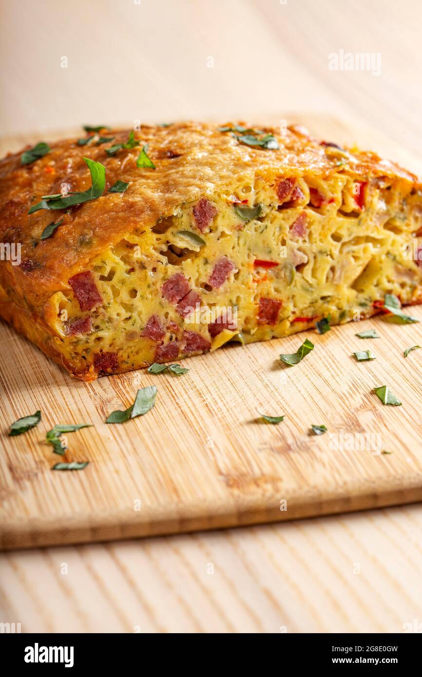 Salted cake made from eggs, cheese, olives, salami, mushrooms and red pepper Stock Photo