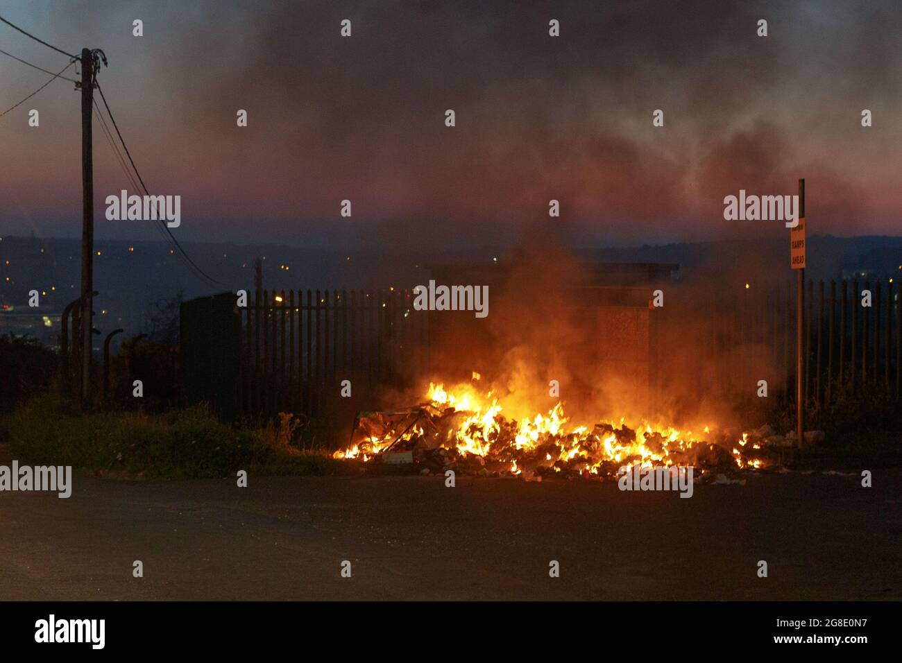 Cork, Ireland. 19th July, 2021. Buring Rubbish at Spring Lane Halting Site, Cork, Ireland. The foul stench of burning rubbish filled the air in the Ballyvolane area of the city this evening as large amounts of rubbish were burnt near the entrance to the Spring Lane Halting Site. The spot is a popular location for illegal dumping despite complaints from many residents and local councillors representing the area. The site is adjacent to Ellis Yard, the location of a €53,000 clean up in 2019. Credit: Damian Coleman/Alamy Live News Stock Photo