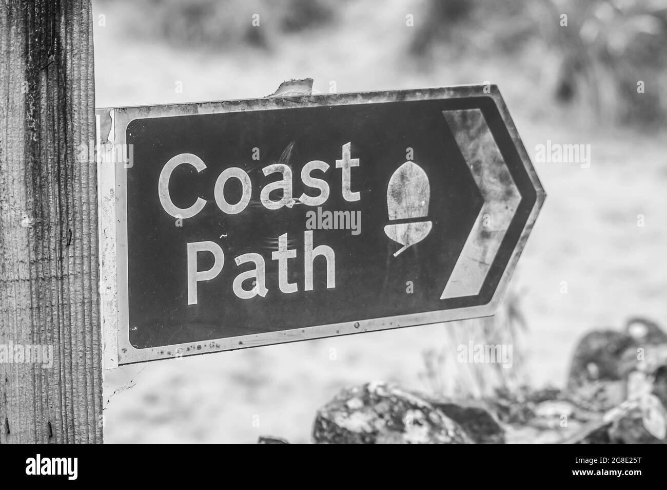 Black and white photo of a coast path directional sign Stock Photo