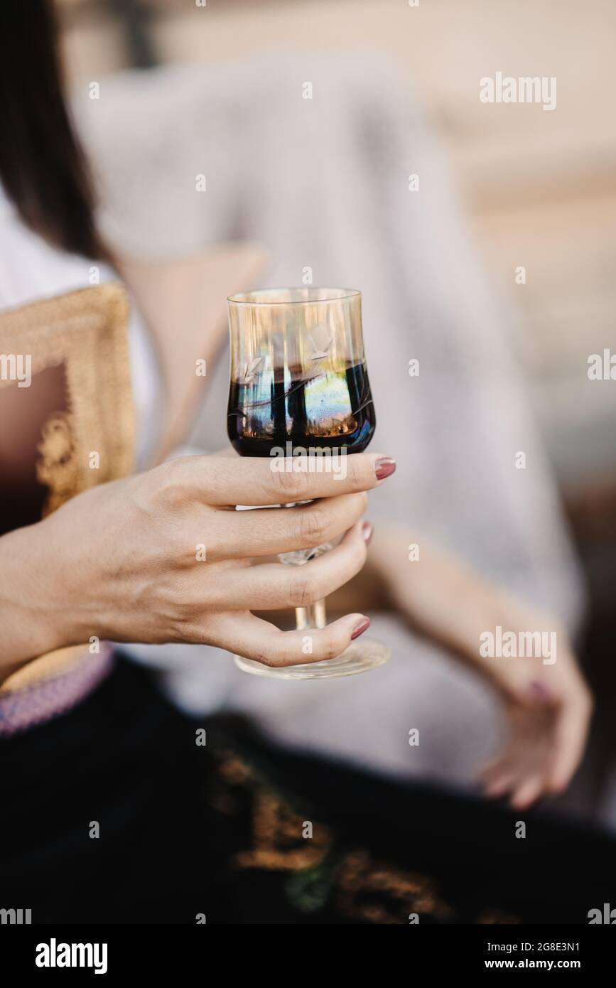 Woman's hand holding a glass of red wine Stock Photo - Alamy