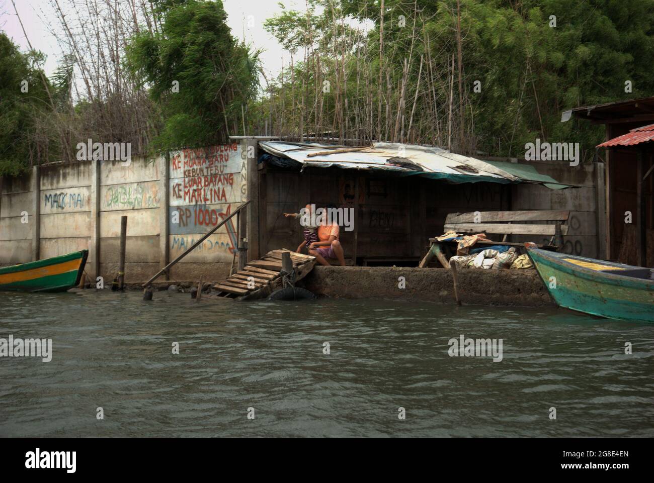 A woman and a child at a boat transportation terminal connecting coastal settlements with Sunda Kelapa port in the coastal area of Jakarta, Indonesia. Stock Photo