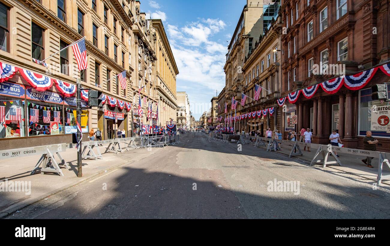 Glasgow, Scotland, UK. 19th July, 2021. PICTURED: On the film set of the new Hollywood blockbuster movie of Indiana Jones 5, people walk around and look at the sights in the city centre. They take pictures and selfies with their cameras phones. The streets are decorated with stars and strips flags and bunting and the Harrison Ford double was seen riding horse back through the streets of Glasgow. Credit: Colin Fisher/Alamy Live News Stock Photo