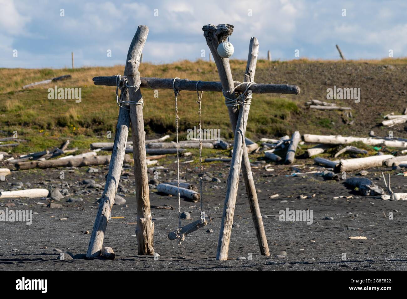 Swing made of driftwood, Sandvik, in the background Saga Island Drangey, Skagafjoerour, North Iceland, Iceland Stock Photo