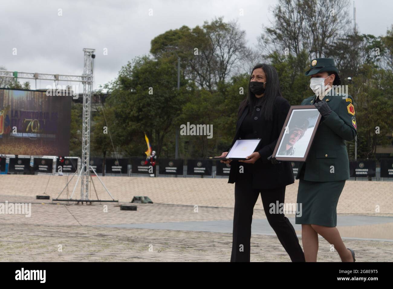 Bogota, Colombia. 19th July, 2021. A close relative of an army member taken  down during combat stands with his photo during a commemorative event to  serve honor to the military and police