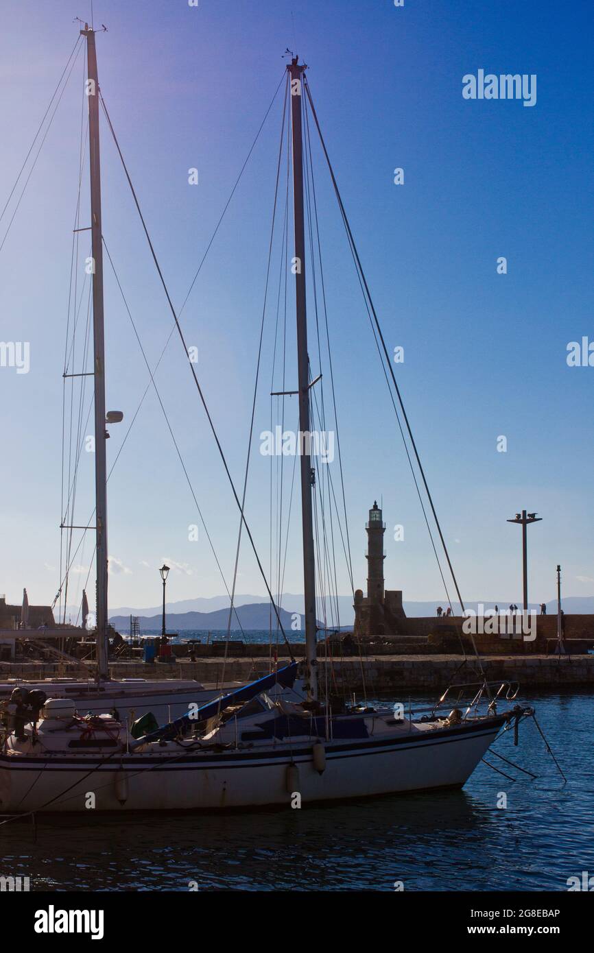 Chania's Venetian lighthouse seen through the masts of boats at anchor on the island of Crete, Greece Stock Photo