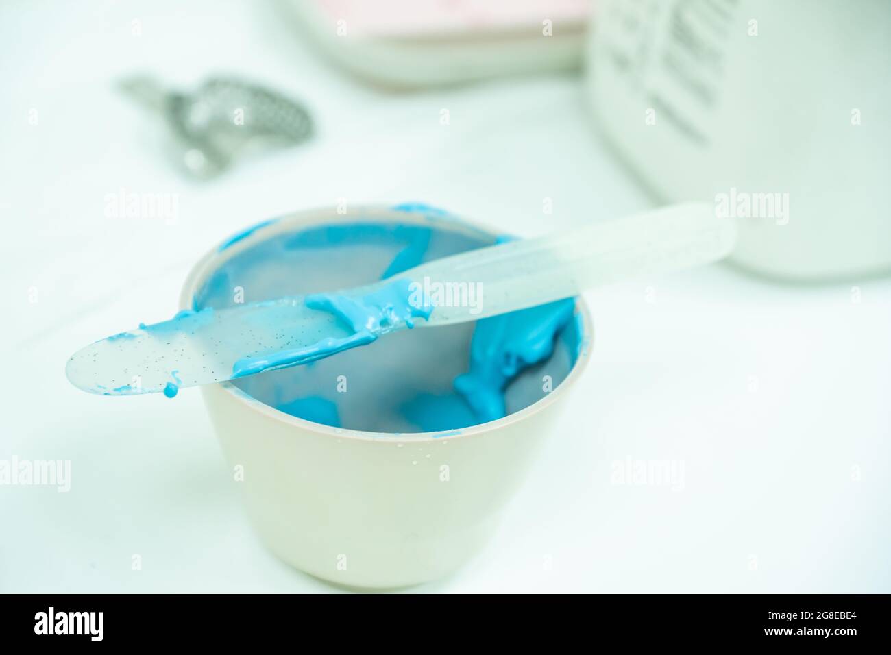 white bowl with blue alginate paste for dental impressions with plastic