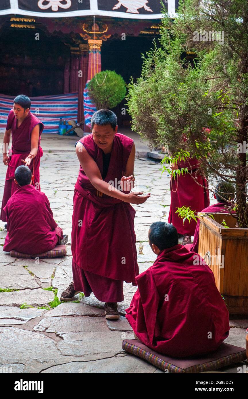 Buddhist monks engage in ritual debate at the Jokhang Temple in Lhasa, Tibet Stock Photo