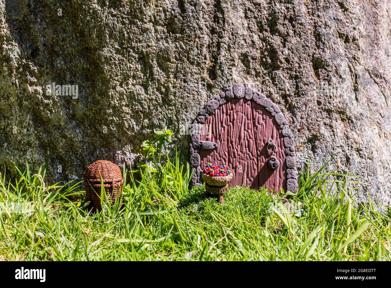Fairy house door made from clay in wall miniature setup. Stock Photo