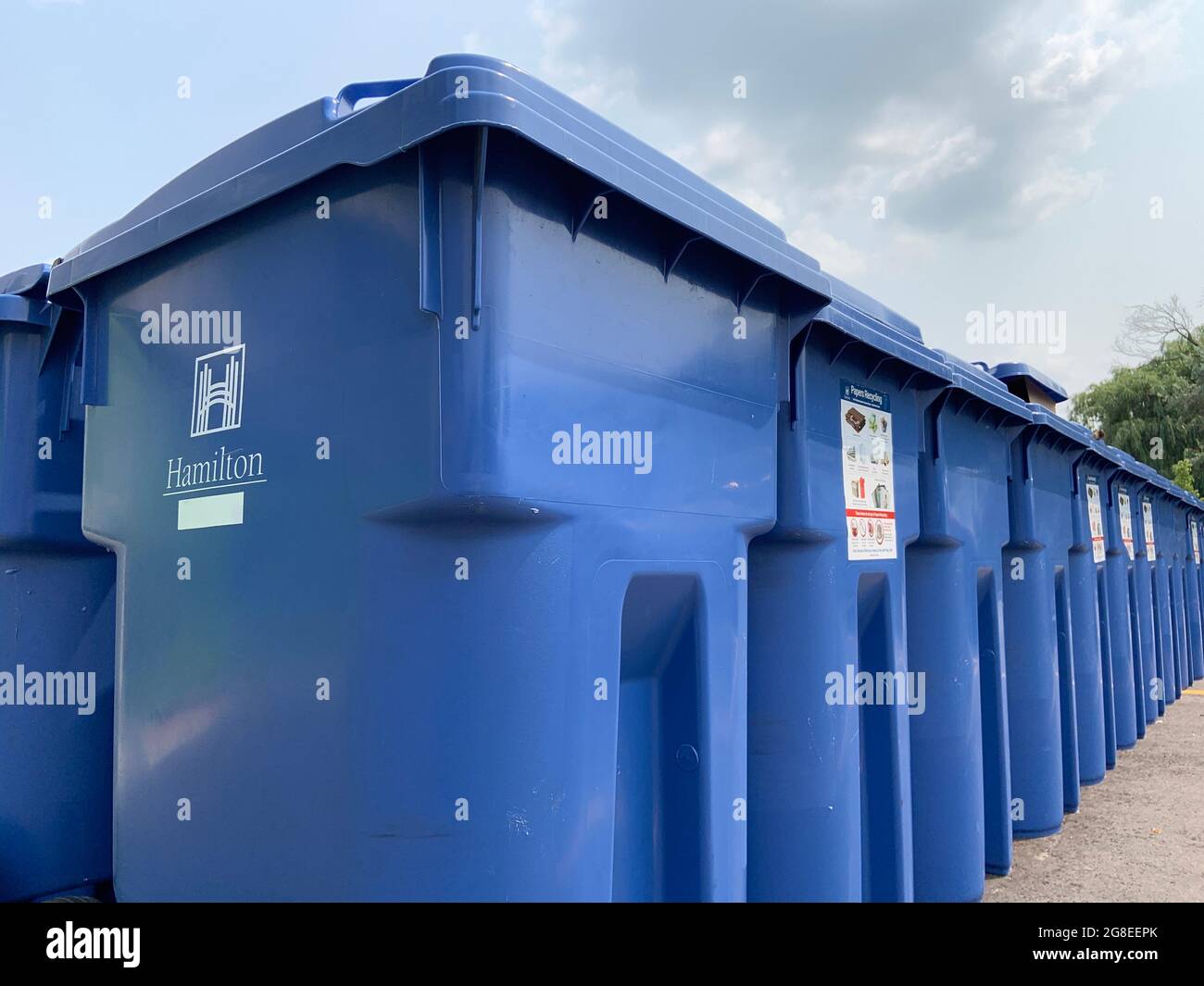 A group of city garbage bins are organized closely together for waste collection at an apartment complex. Stock Photo