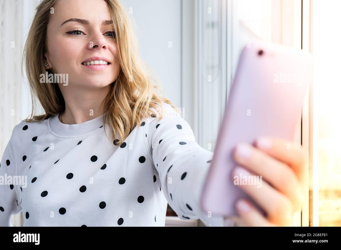 Blonde young girl taking selfie. Video call. Online education. Work from  home. Woman holding smartphone. Phone call. Recording new vlog for her  channel. Blogger Conference Stock Photo - Alamy