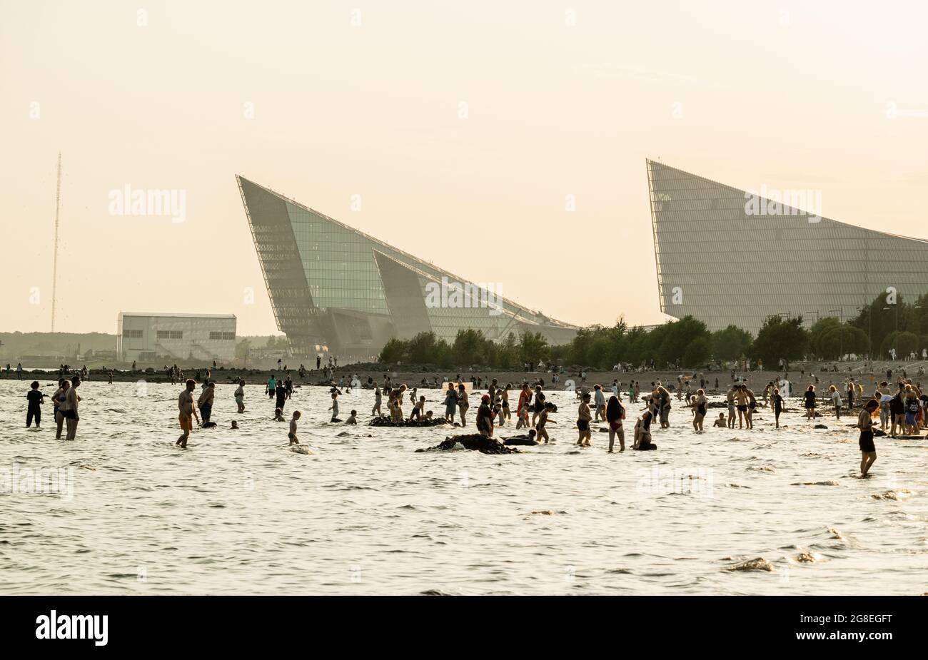 Silhouettes of people bathing in Finnish Gulf in the evening, at beach of Park of 300th anniversary of st Petersburg, Russia Stock Photo