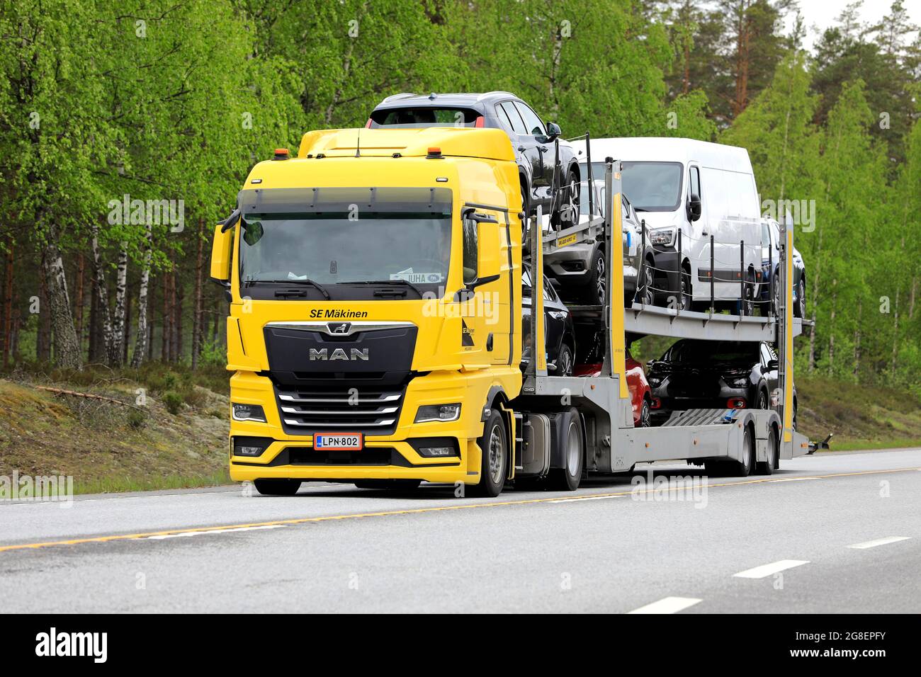New MAN TGX car carrier truck transports vehicles along highway on a day of summer. Raasepori, Finland. May 27, 2021. Stock Photo