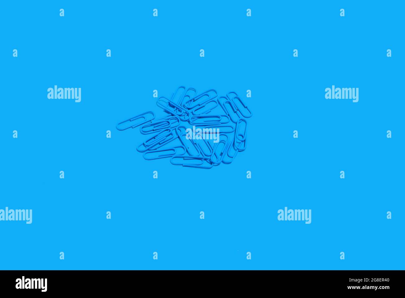 heap of blue paper clips, school accessories Stock Photo
