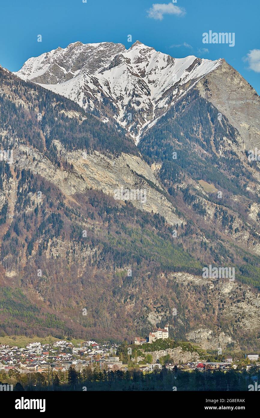 Contrast of tiny human settlement Balzers and slopes of Raetikon massif at border of Liechtenstein, Austria and Switzerland Stock Photo