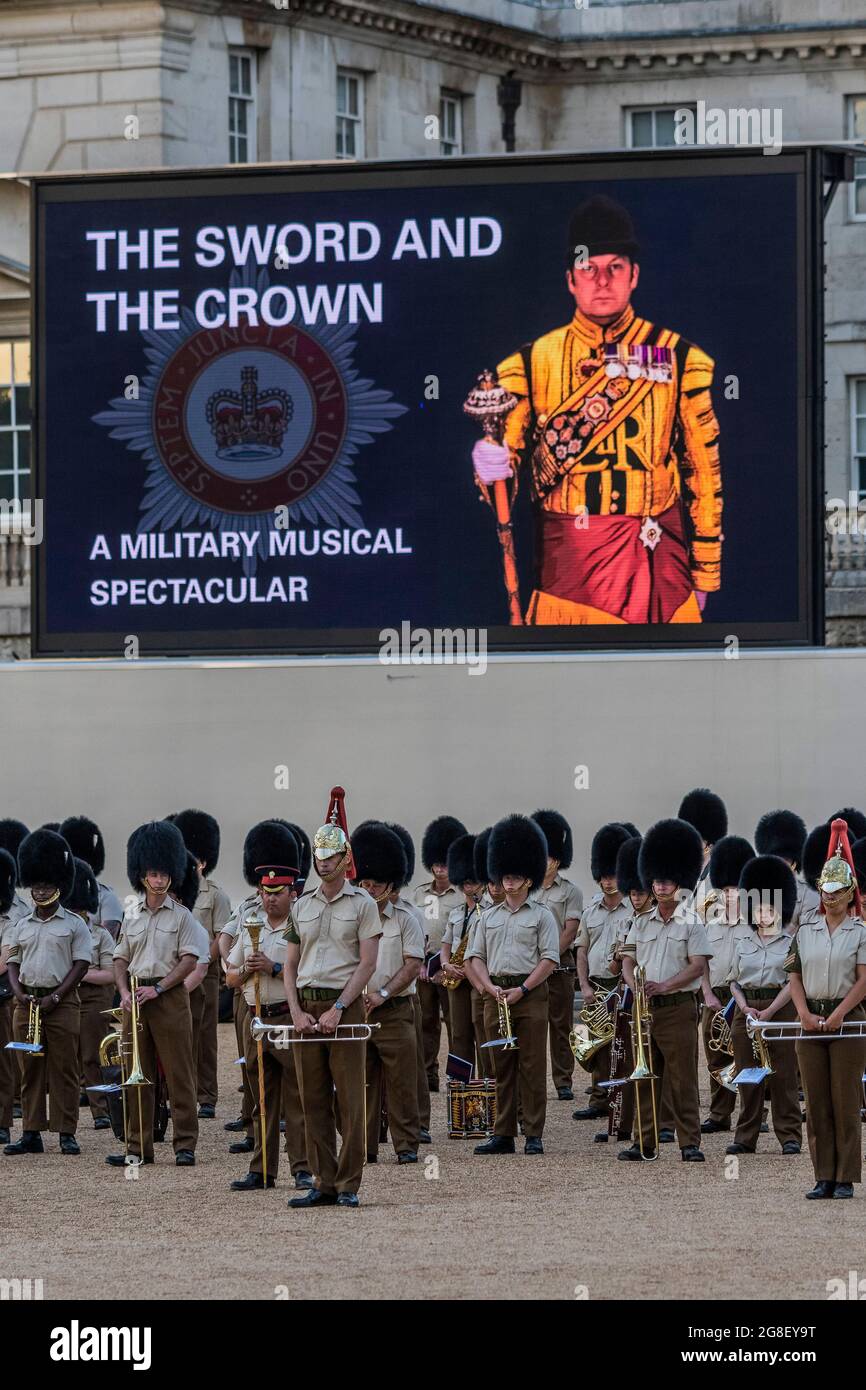 London, UK. 19th July, 2021. Members of the bands of the Grenadier, Coldstream, Scots, Irish and Welsh Guards and representatives from the 1st Battalion Grenadier Corps of Drums preview their musical programme from The Sword & The Crown which includes arrangements by members of the band and an interpretation of the music usually associated with secret agent James Bond. The final rehearsal ahead of the performances due to take place on 20/21/22 July on Horse Guards Parade. Credit: Guy Bell/Alamy Live News Stock Photo