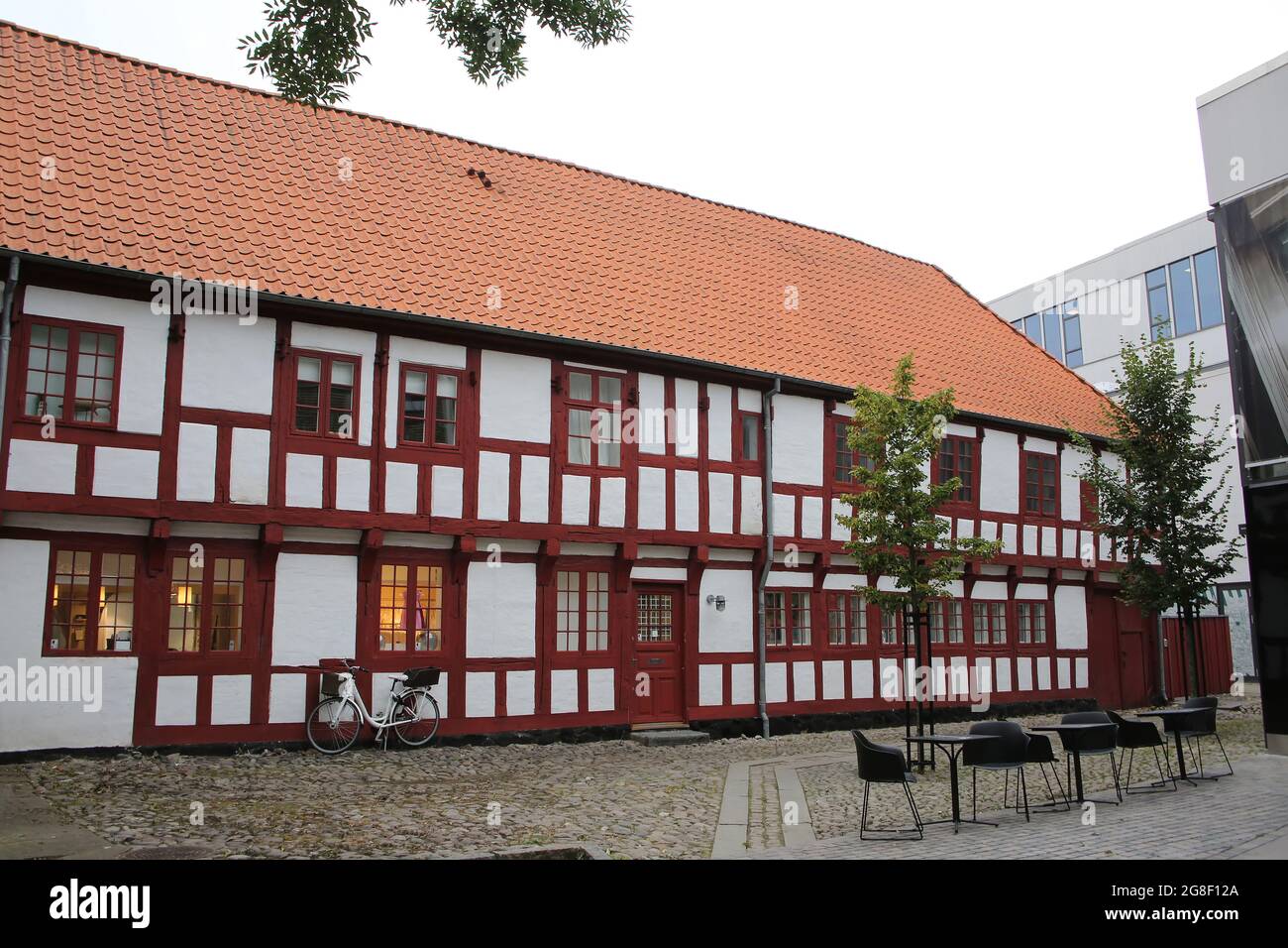 Historic white and red painted timbered building with cobble stones in the city center, Aalborg, Denmark. Stock Photo