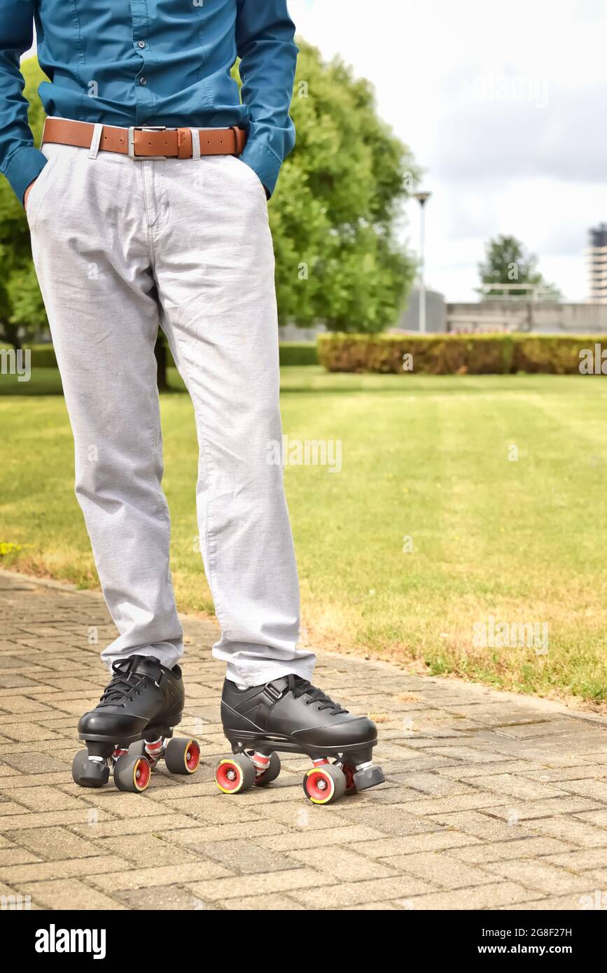 Man's legs in pants and roller skates while skating and outdoor