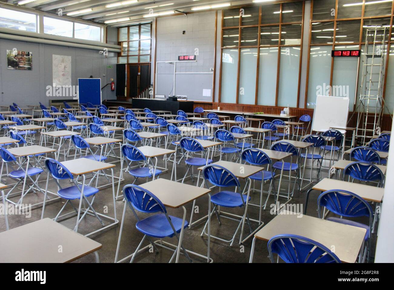 english school hall full of lines of chairs and tables for examinations