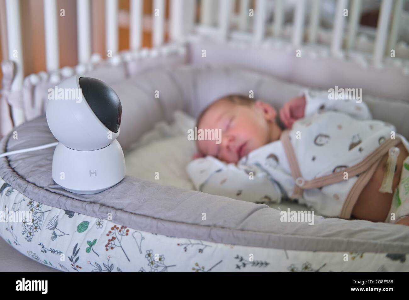 A surveillance camera Xiaomi Mi Home looks at the crib with a sleeping  newborn baby - Moscow, Russia, June 27, 2021 Stock Photo - Alamy