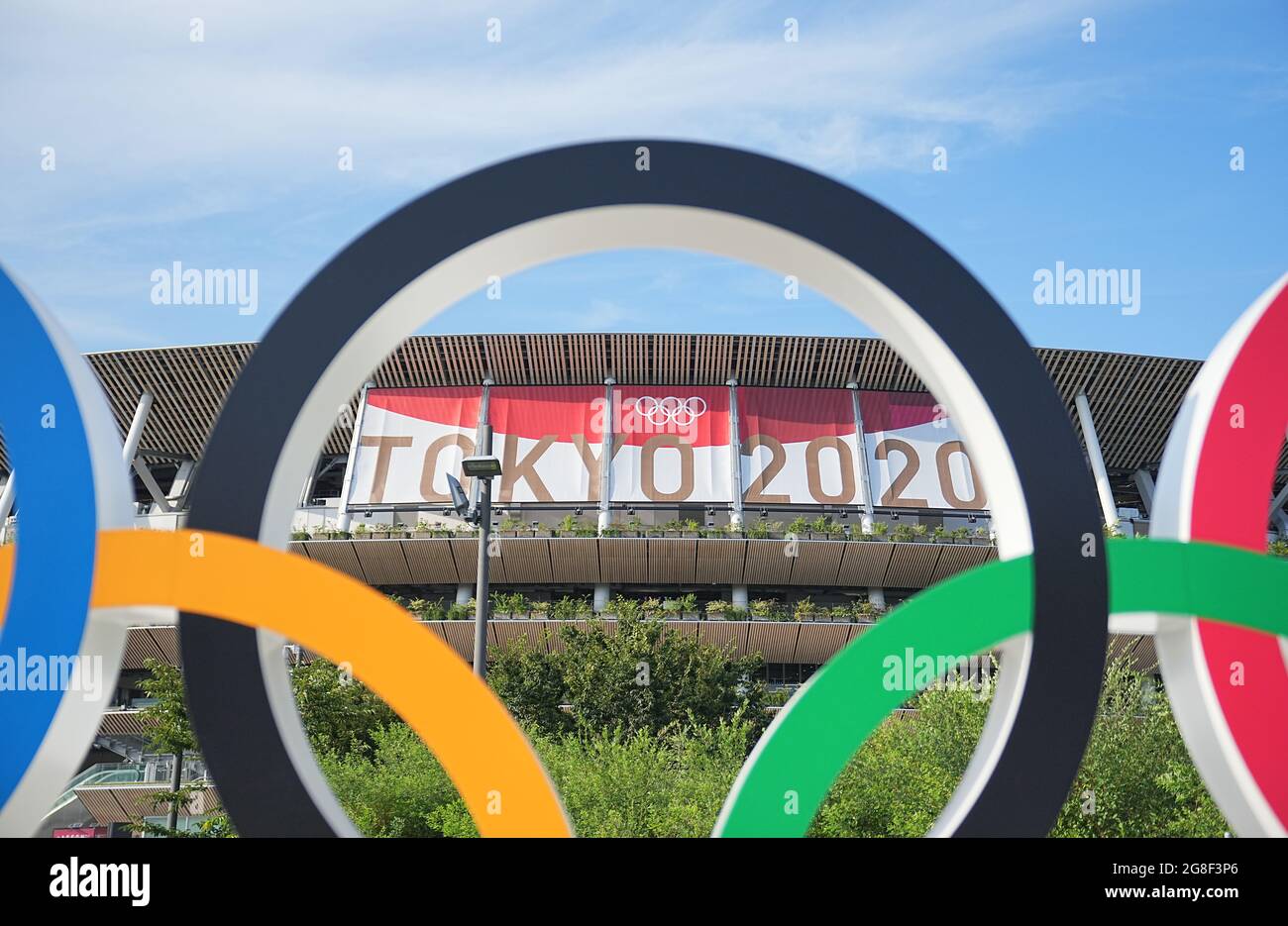 20 July 2021, Japan, Tokio: Olympic rings stand in front of the Olympic Stadium. The Olympic Stadium is the sports venue of the opening ceremony and closing ceremony as well as for the track and field athletes and football. The Olympic Games 2020 Tokyo will take place from 23.07.2021 to 08.08.2021. Photo: Michael Kappeler/dpa Stock Photo