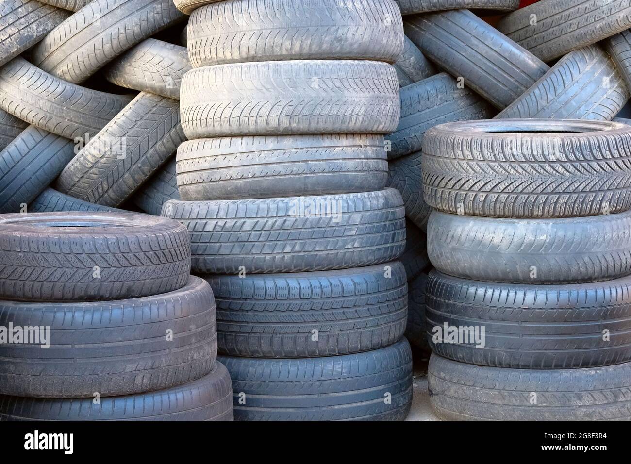 Recycling materials concept. Lots of black used car tires stacked in a pile. Car recycling. Ecology environment protection. Stock Photo