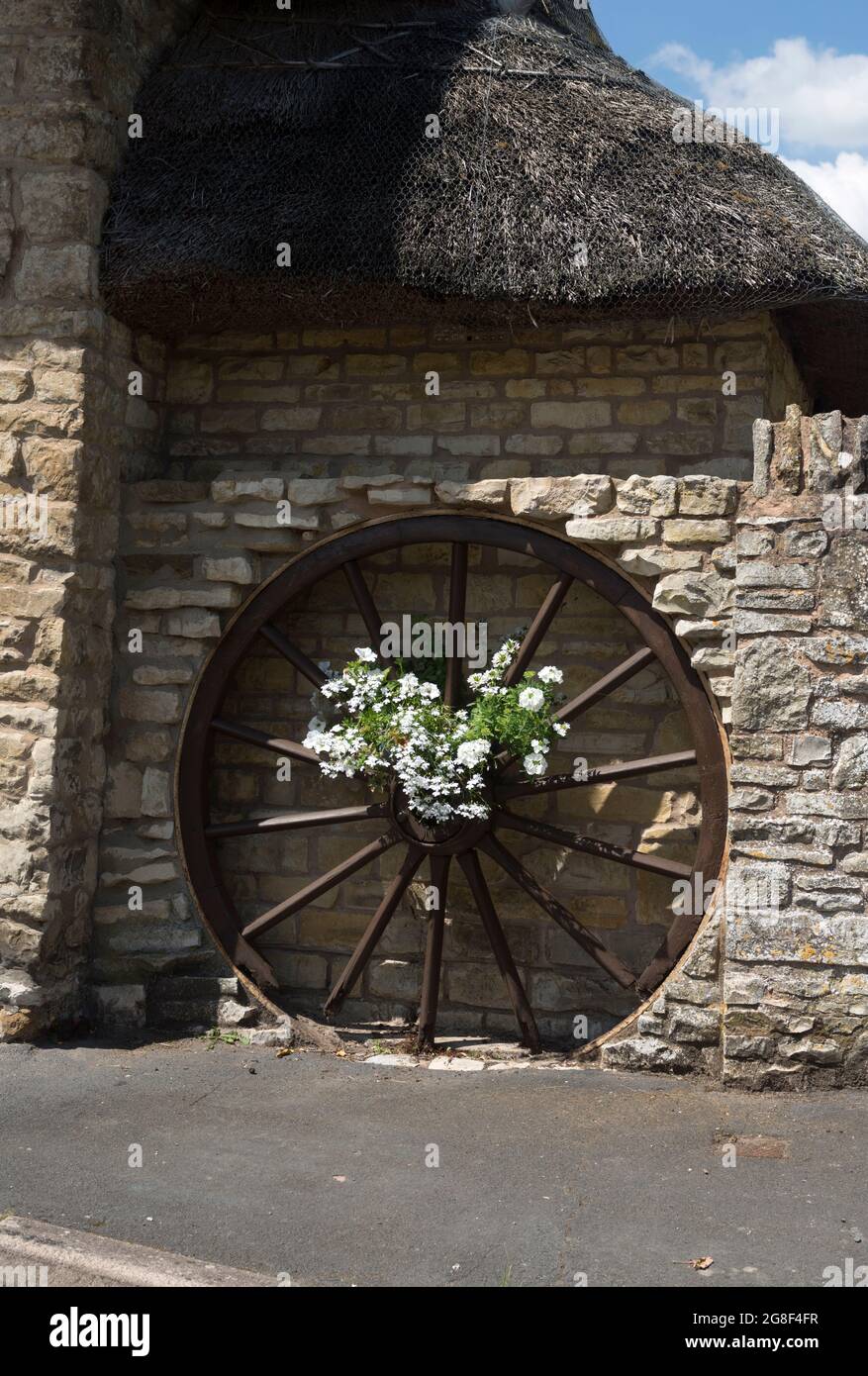 Cartwheel floral decoration on a cottage, Combrook, Warwickshire, England, UK Stock Photo
