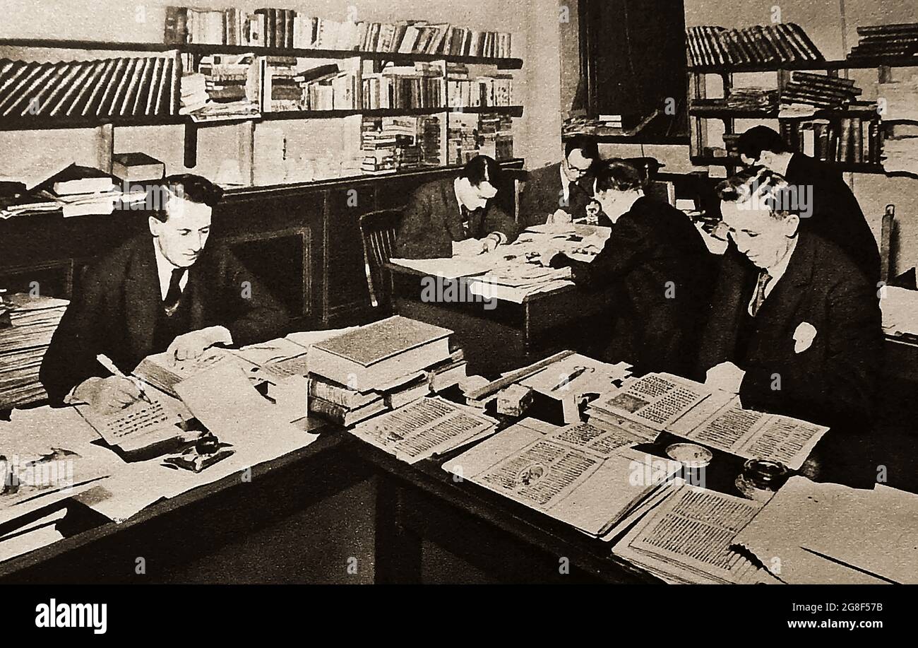 Editors working at the Greycaine Book Manufacturing Company, UK, Circa 1940s (a pioneer  in the mass production of quality books sold at reasonable prices). The company began operating  on what is now the Greycaine Industrial Estate in North Watford in 1926.  The company took its name from its Directors, Frank Grey (real name  Francis John Christian Gruneisen) and Gordon Ralph Hall Caine, both of which had bookbinding backgrounds. Caine was later a Conservative Party M.P. Stock Photo