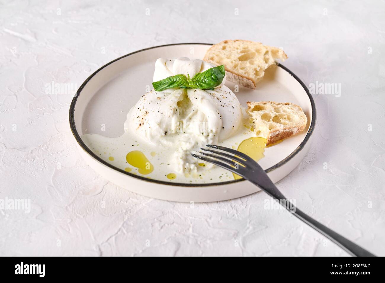 Italian cut burrata cheese with ciabatta bread and olive oil on white