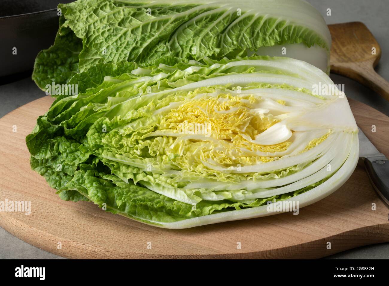 Whole and half fresh raw Chinese cabbage close up on a cutting board