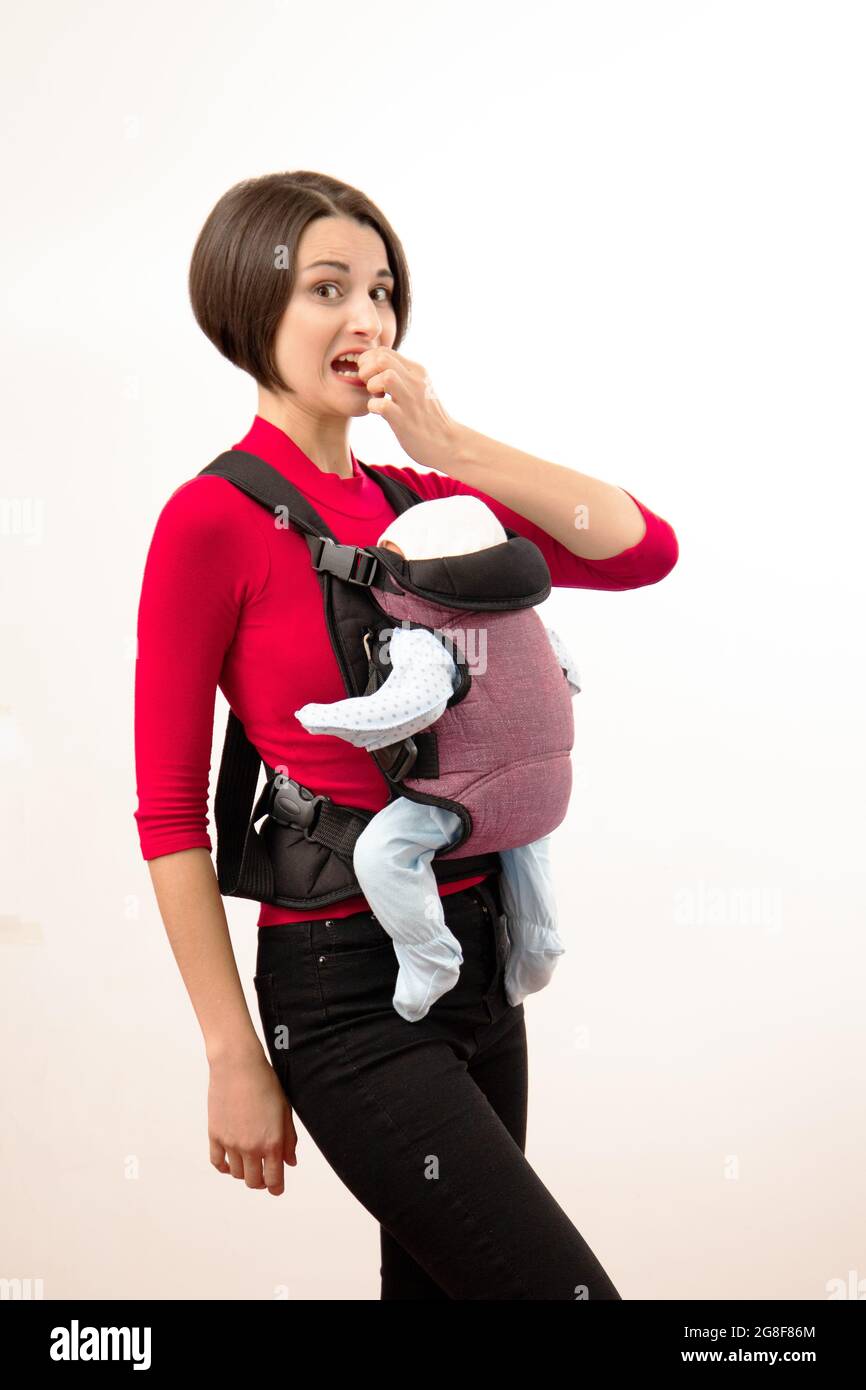 Babywearing confused young mother with baby in not ergonomic carrier. Isolated on white Stock Photo Alamy