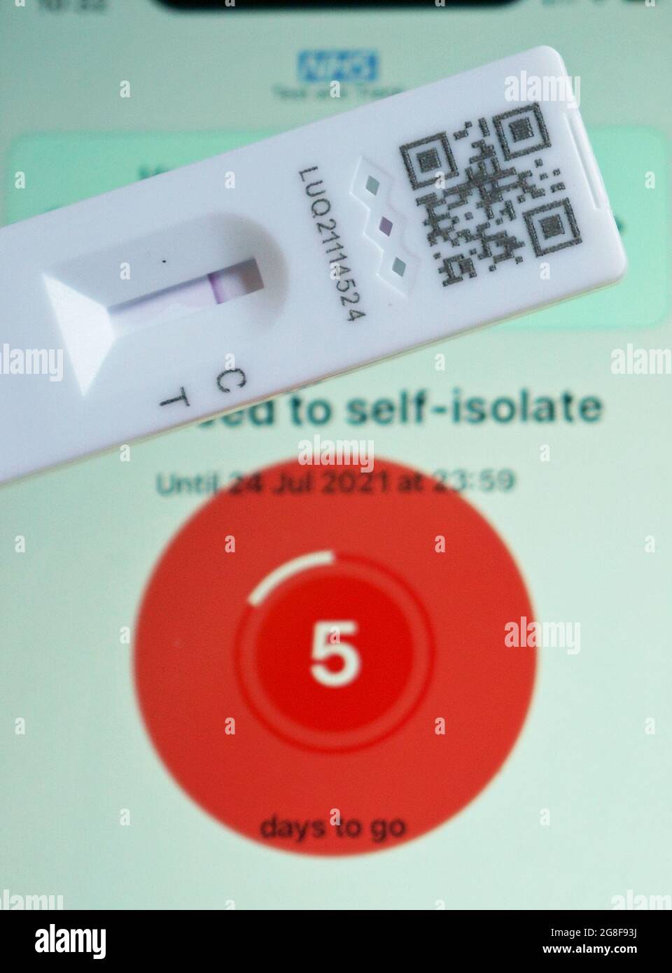 A negative lateral flow test next to advice from the NHS COVID app on an iphone to self isolate. Picture date: Tuesday July 20, 2021. Stock Photo