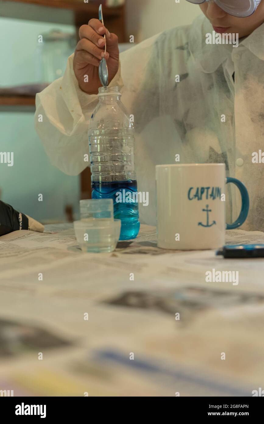 kid play precision chemical game indoor at home lab with glasses Stock