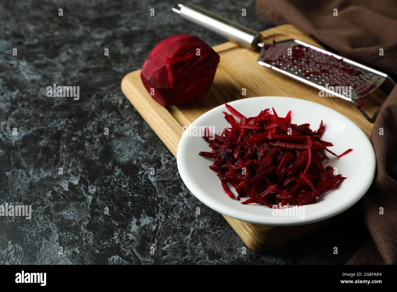 Fresh grated beets on black smokey table Stock Photo