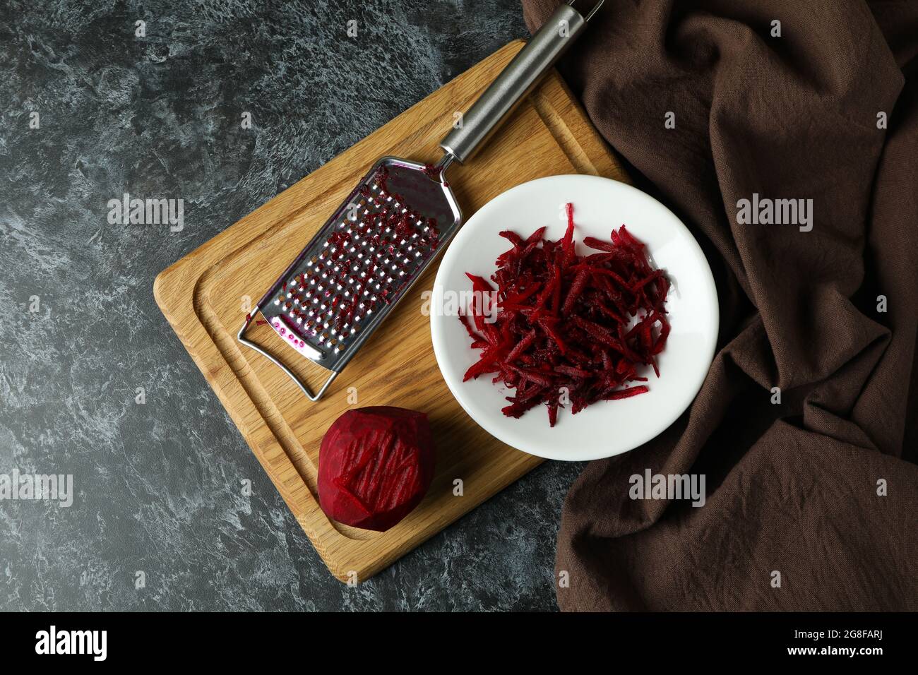 Fresh grated beets on black smokey table Stock Photo