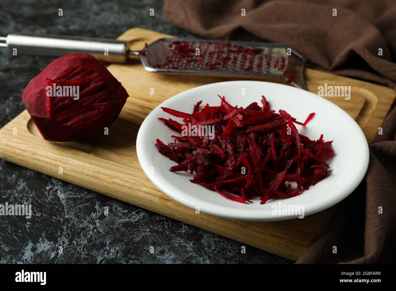 Fresh grated beets on black smokey table Stock Photo