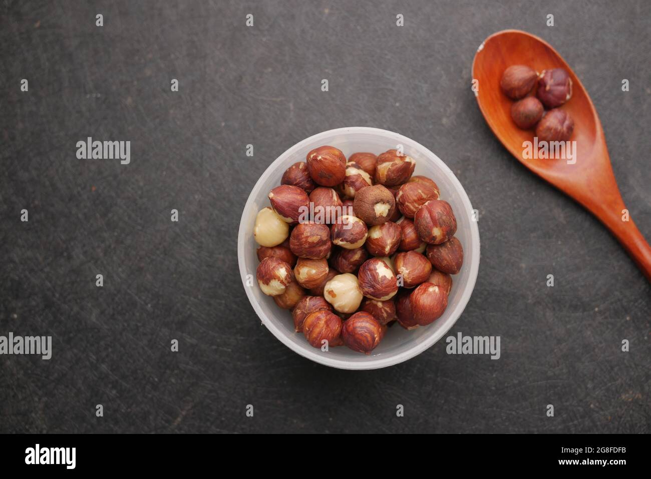 hazelnuts in a container on black background, Stock Photo